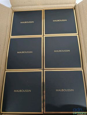 quatre boîtes de produits de maquillage dans un carton posé sur une table