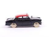 a black toy car with a red top on a white surface