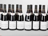 six bouteilles de vin rouge sont alignées sur une table