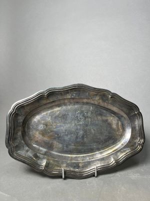 an antique silver plate with a decorative edge on a table