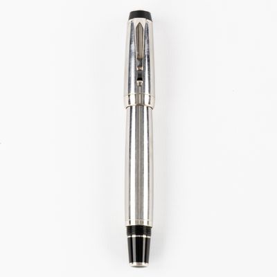 un gros plan d'un stylo posé sur une surface blanche