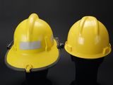 two yellow hard hats sitting next to each other on a black surface