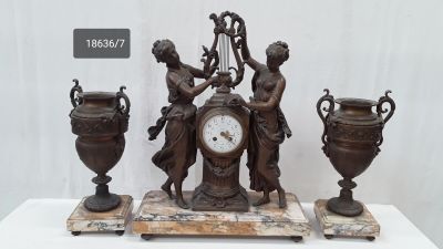 une horloge posée sur une table à côté de deux vases