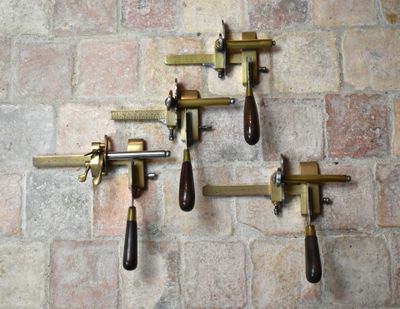 quatre pièces de laiton et de bois suspendues à un mur de briques
