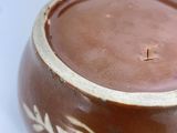 a brown and white bowl on a white surface