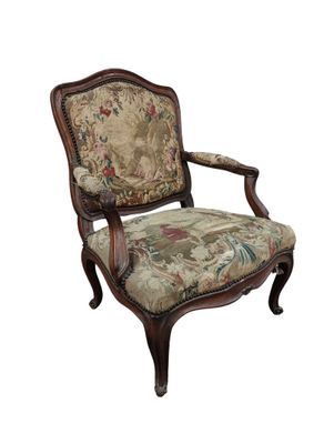 une image d'une chaise en bois dont l'assise est recouverte d'un rembourrage floral