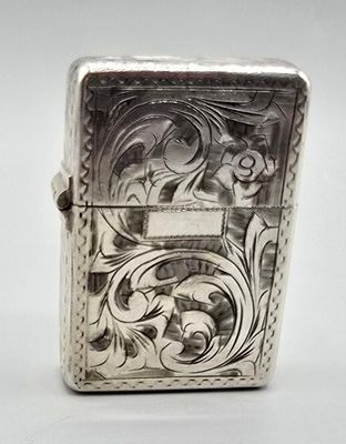 un briquet ancien en argent orné d'un motif floral sur le devant