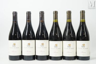 six bouteilles de vin sont alignées sur une table