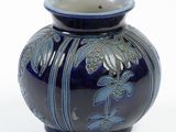 a blue vase with a bird on it on a white background