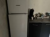 a refrigerator and a microwave in a small kitchen