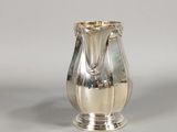 a silver vase that is sitting on a table