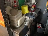 une petite cuisine avec des casseroles et des poêles sur les étagères