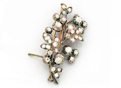 une image représentant une broche en forme de fleurs sertie de diamants, sur fond blanc