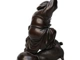 a statue of a person sitting on a stool