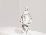 sculpture représentant un homme à cheval, posée sur un socle dans une pièce blanche