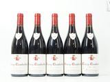 six bouteilles de vin rouge sont alignées sur une surface blanche