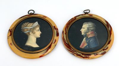 deux portraits encadrés représentant un homme et une femme sur fond blanc