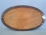 a wooden oval shaped object with a string on it