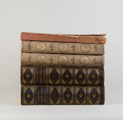 trois livres empilés sur une surface blanche