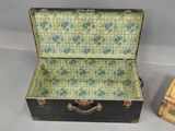 a small black suitcase with a green floral pattern inside