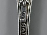 a silver spoon with a design on it on a table