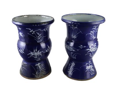 deux vases bleus ornés de fleurs sur fond blanc