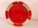 a red and gold plate sitting on a white table