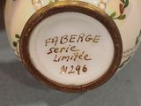 a hand holding a small vase with a label on it
