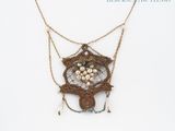an image of a close up of a necklace on a white surface
