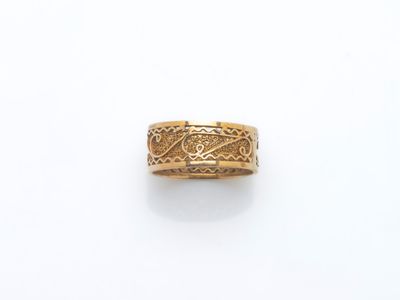 gros plan d'une bague en or sur une surface blanche