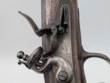 a close up of a gun with a metal handle on a white background