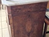 a wooden table with a marble top in the middle of a room