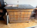 a wooden dresser with a marble top in a room