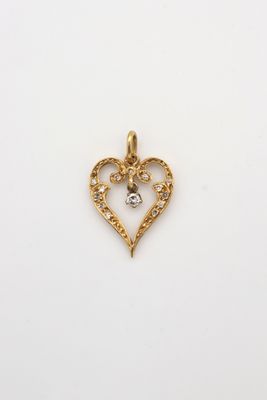 un pendentif en forme de cœur en or, orné d'un diamant au centre