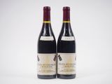 deux bouteilles de vin rouge posées l'une à côté de l'autre sur une surface blanche