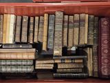 de nombreux livres anciens dans une boîte rouge posée par terre