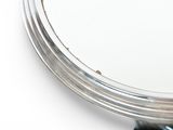 a close up of a mirror on a white surface