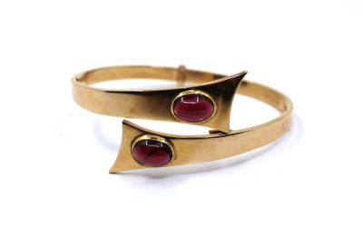 a close up of a gold ring with two red stones on it