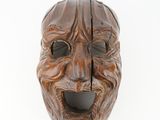 an image of a wooden mask on a white surface with a white background