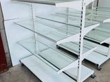 many shelves with glass shelves on them in a store