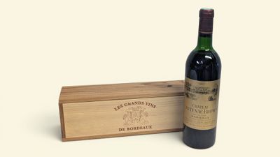 une bouteille de vin posée à côté d'une caisse en bois