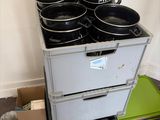 a stack of pots and pans sitting on top of a stack of boxes