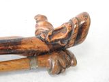 a close up of a wooden walking stick with an animal on it