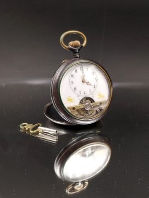 une montre de poche en argent posée sur une table, attachée à une chaîne