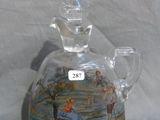 a glass bottle with a picture on it on a table