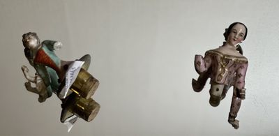 two figurines hanging from the ceiling of a room