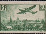 an old stamp with a picture of a plane flying over a city
