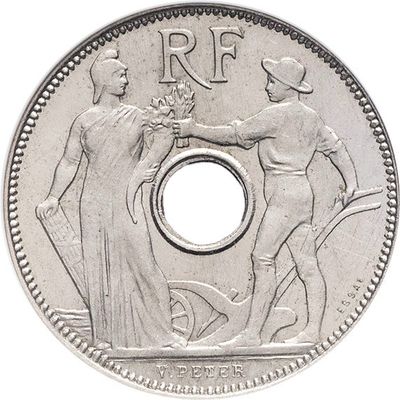 Gros plan sur une pièce de monnaie en argent sur laquelle figurent une femme et un homme.