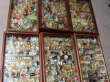 quatre cadres en bois remplis d'objets en verre de toutes sortes, posés par terre