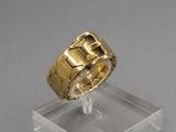 une photo d'une bague en or posée sur un socle transparent